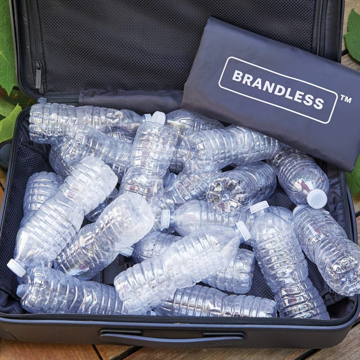 Checked luggage bag full of empty single-use bottled waters, demonstrating how many bottles the use of recycled materials in the luggage liner are kept out of landfills.