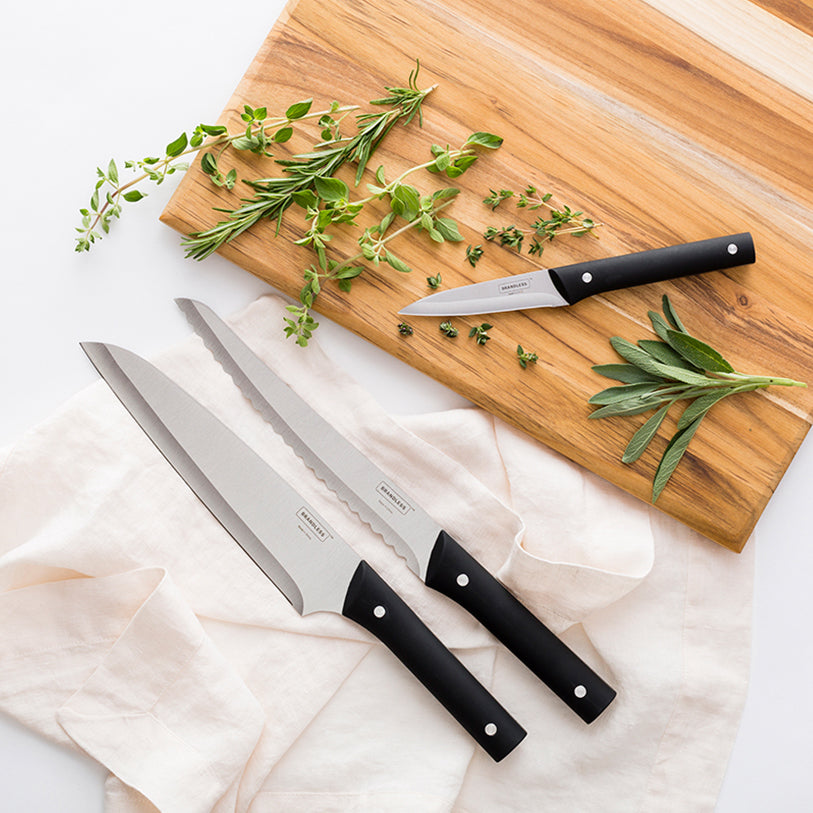 Lifestyle shot of paring knife, bread knife, and santoku knife