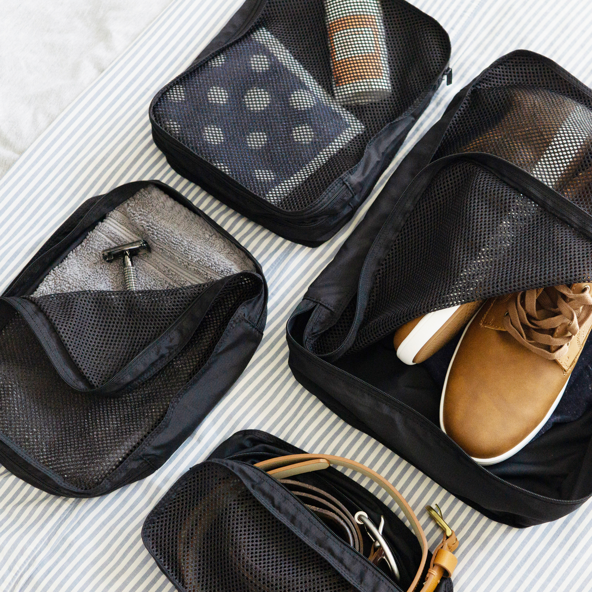4 packing cubes shown packed with shoes, belts, toiletries, and clothing to demonstrate the versatile organization the packing cubes can provide and how easily visible the contents of the bags are so you always know where to look.