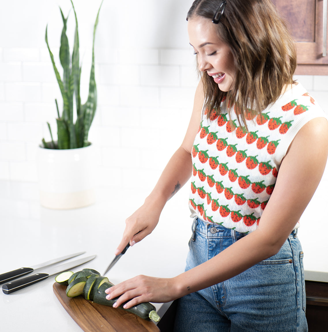 Lifestyle shot showing woman cutting with Brandless knives