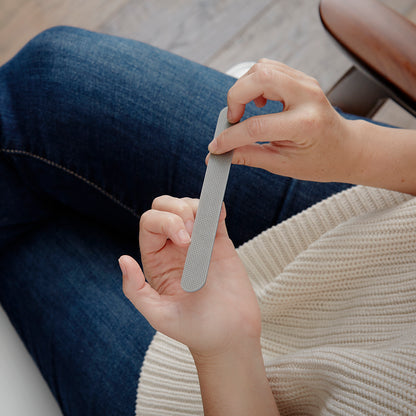 Lifestyle photo, woman completes some quick nail maintenance while seated.