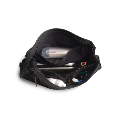 Lifestyle.  Top down view of a loaded travel organizer unzipped and splayed open to show the case holding and organizing glasses cases, eye drops, ear plugs, headphones, and misc easily in separate internal compartments.