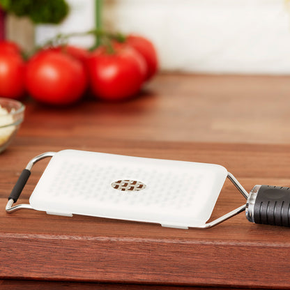 Cheese grater shown with it's white plastic clip-on blade guard which makes storage in drawers easy and safe for both your fingers and keeping the blades sharp.