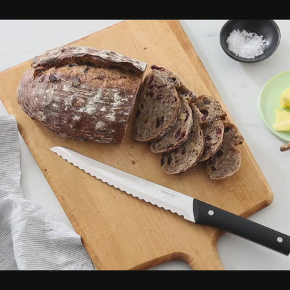 Video of a woman's hands slicing cranberry wheat bread with the Brandless Bread Knife on a wood cutting board.