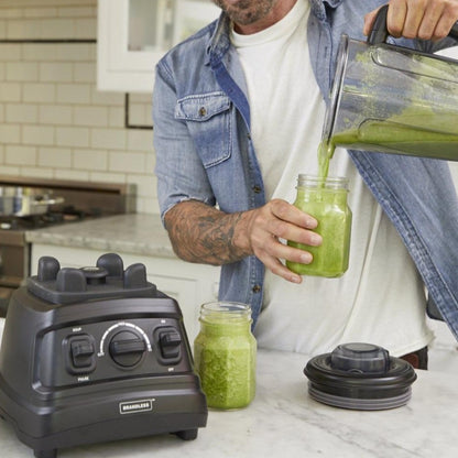 Lifestyle photo, man pouring a pesto smoothie into a Mason jar.