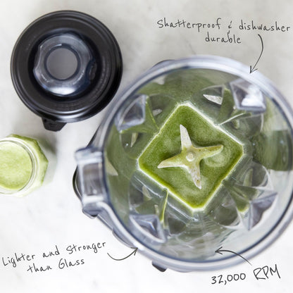 Top view of blender with a green pesto soup mix, showing stainless steel blades, shatterproof and dishwasher durable, lighter and stronger than glass carafe, and 32000 rpm motor.