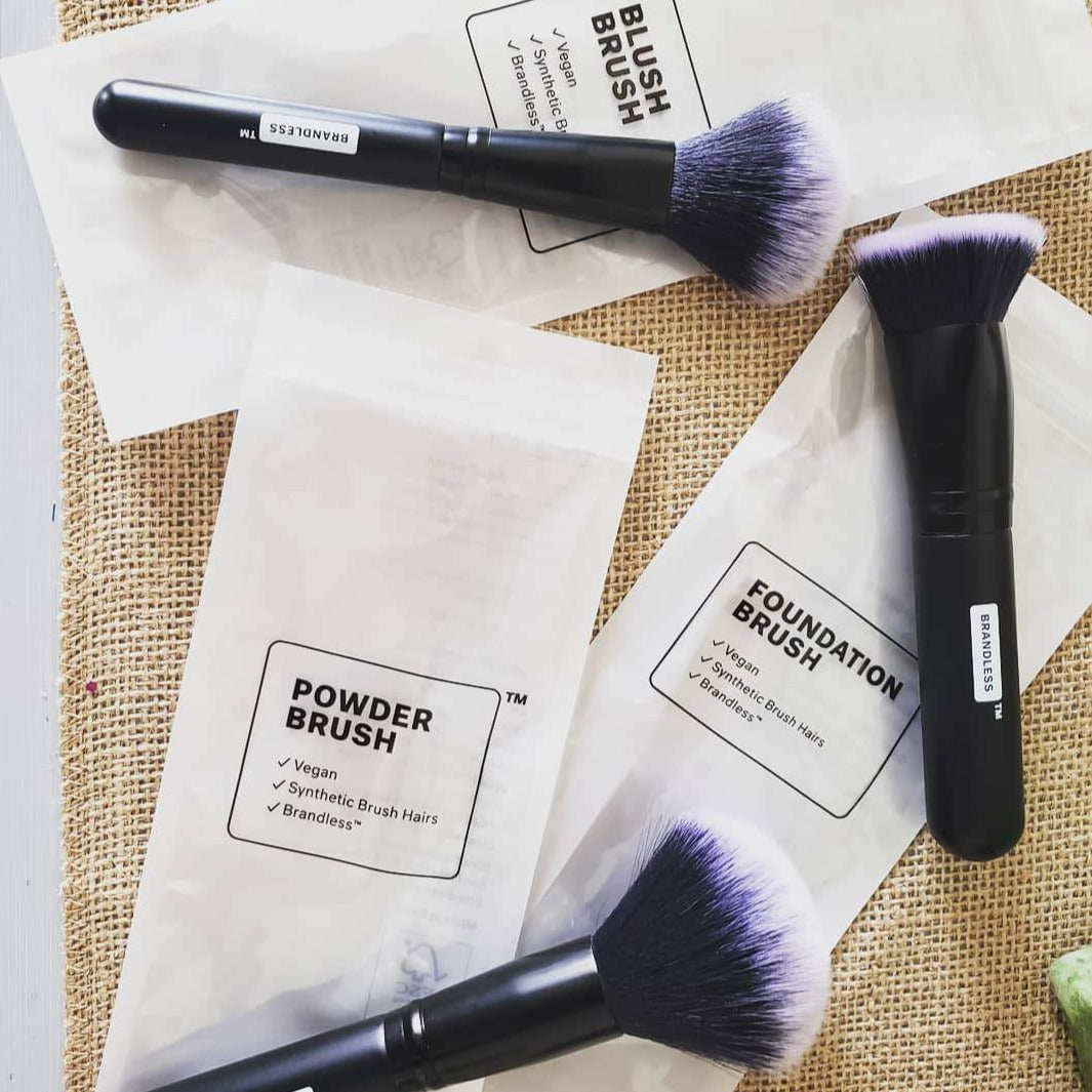 Lifestyle, set of three brandless makeup brushes splayed on table. Blush Brush. Foundation Brush. Powder Brush.