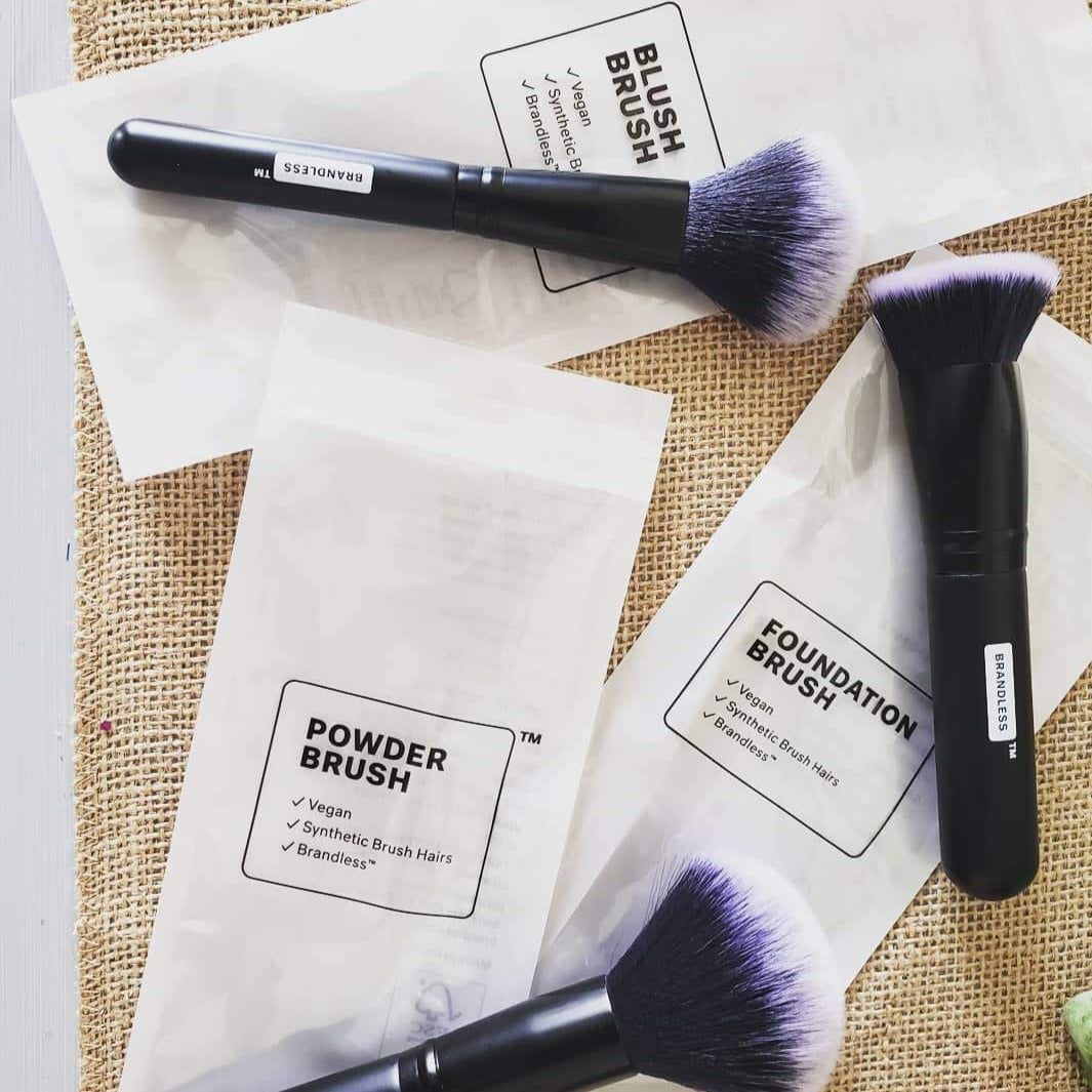 Lifestyle, set of three brandless makeup brushes splayed on table.  Blush Brush. Foundation Brush. Powder Brush.